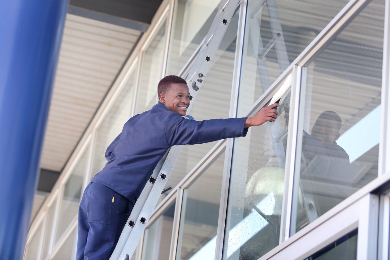 A worker cleaning windowns of the office
