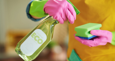  employee wearing cleaning gloves holding eco friendly spray
